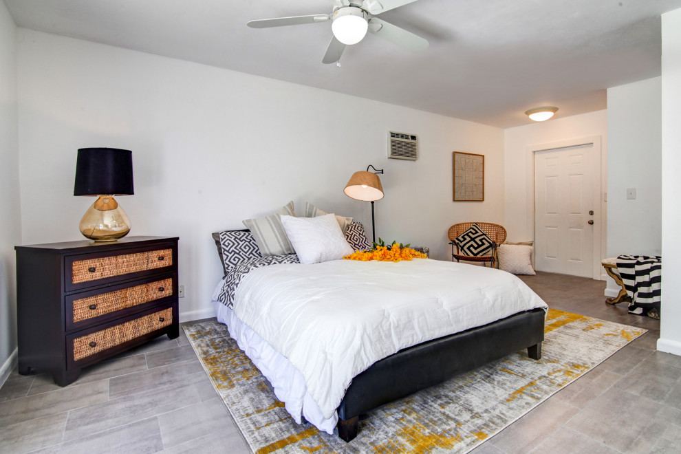 マイアミにある巨大なビーチスタイルのおしゃれな主寝室 (磁器タイルの床、グレーの床) のレイアウト