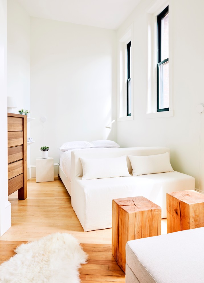 Idées déco pour une petite chambre d'amis scandinave avec un mur blanc, parquet clair et un sol beige.