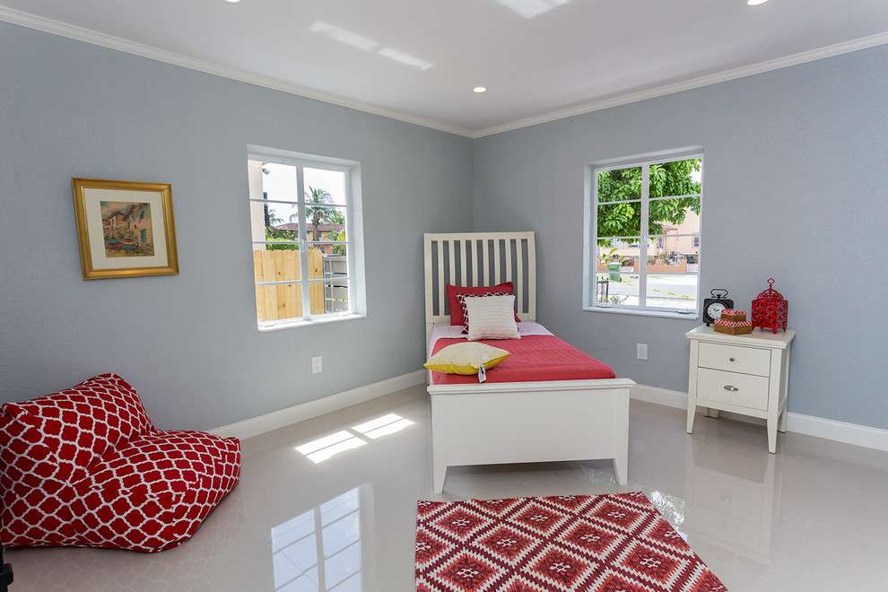 Example of a mid-sized trendy linoleum floor and white floor bedroom design in Miami with blue walls and no fireplace