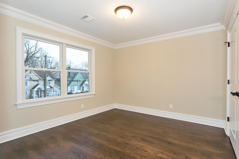 Cette photo montre une chambre d'amis moderne de taille moyenne avec un mur beige et un sol en bois brun.