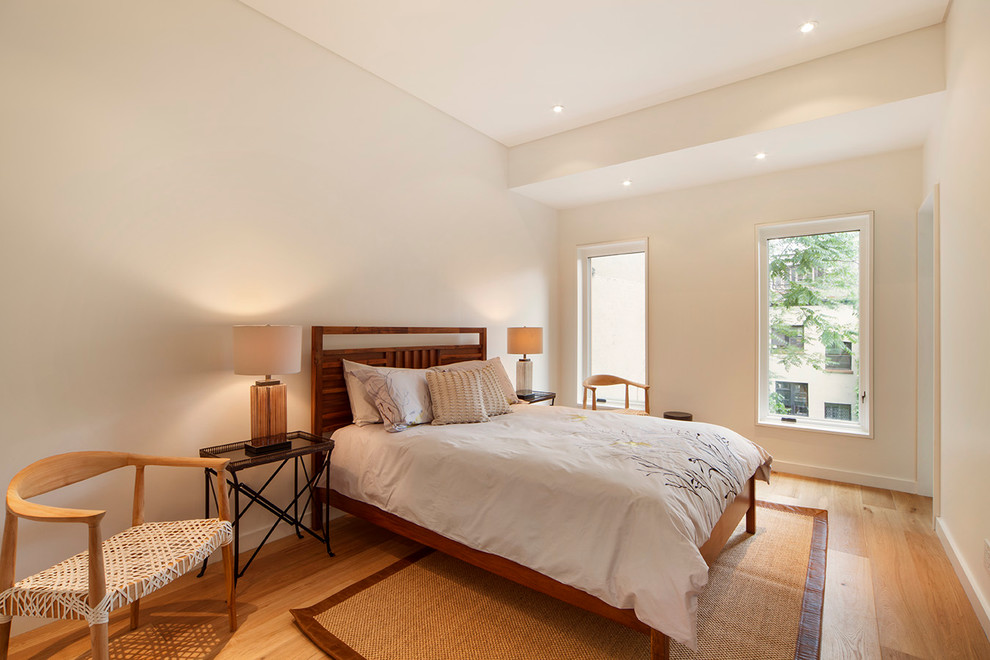 На фото: спальня в современном стиле с белыми стенами и паркетным полом среднего тона без камина с