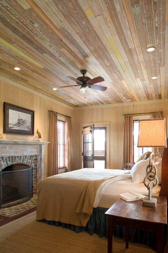 Elegant medium tone wood floor bedroom photo in Atlanta with beige walls, a standard fireplace and a brick fireplace