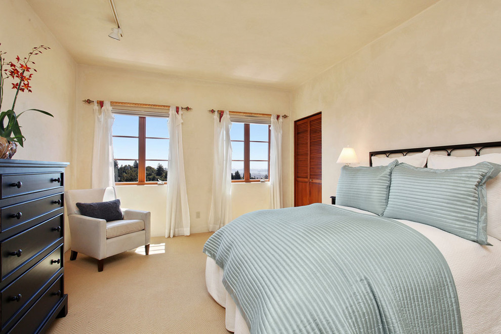 На фото: спальня в средиземноморском стиле с бежевыми стенами и ковровым покрытием без камина с