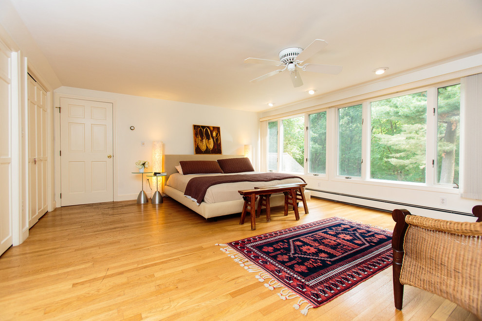 Aménagement d'une chambre parentale classique de taille moyenne avec un mur blanc et un sol en bois brun.