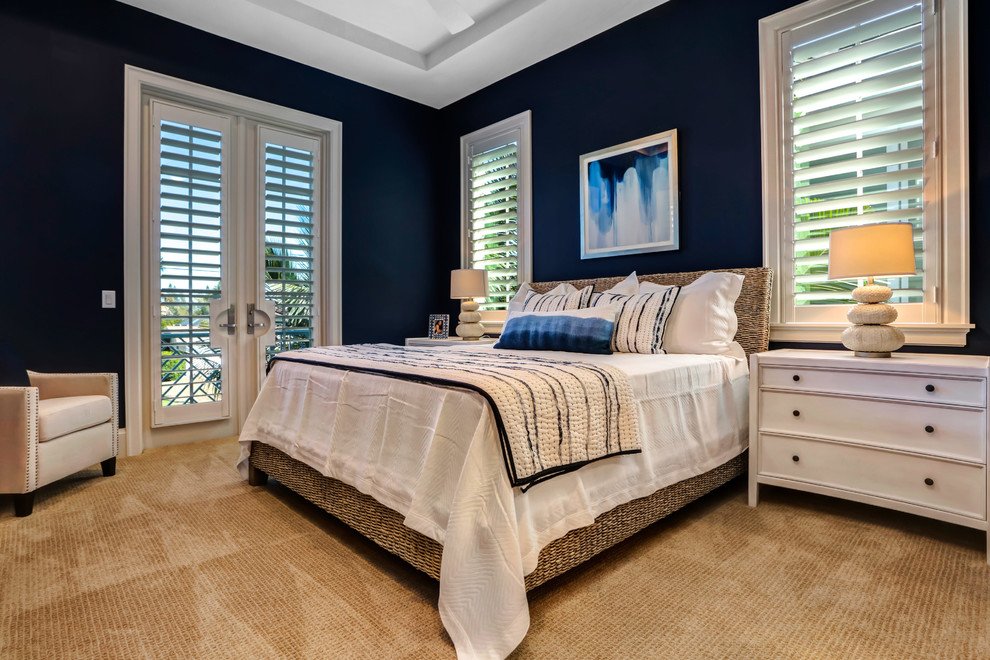 На фото: хозяйская спальня в морском стиле с синими стенами, ковровым покрытием и коричневым полом с