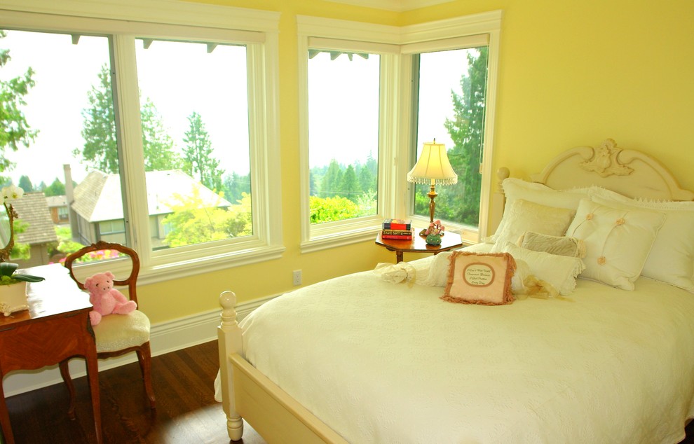 Bild på ett mellanstort vintage sovrum, med gula väggar och mellanmörkt trägolv