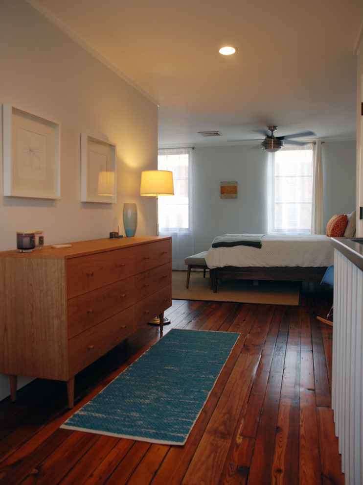 This is an example of a small contemporary master bedroom in Philadelphia with grey walls and light hardwood flooring.