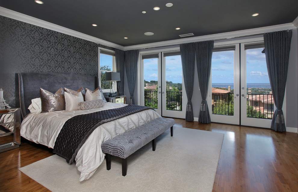 Großes Modernes Hauptschlafzimmer ohne Kamin mit grauer Wandfarbe, braunem Holzboden und braunem Boden in Orange County