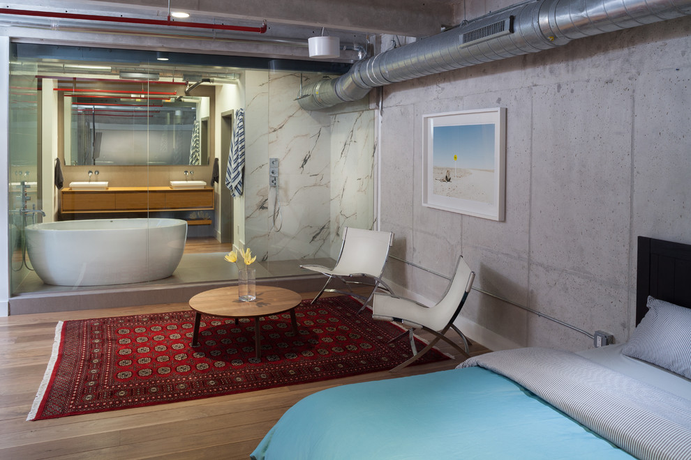 Diseño de dormitorio urbano sin chimenea con paredes grises y suelo de madera en tonos medios