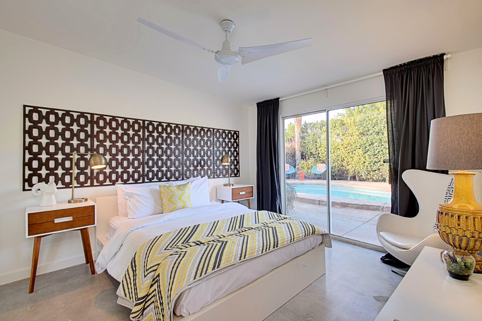 Immagine di una camera degli ospiti minimalista di medie dimensioni con pareti bianche e pavimento in cemento