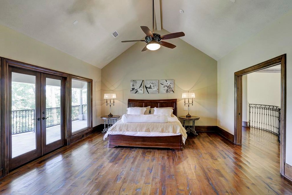 Geräumiges Mediterranes Gästezimmer ohne Kamin mit gelber Wandfarbe, braunem Holzboden und braunem Boden in Houston