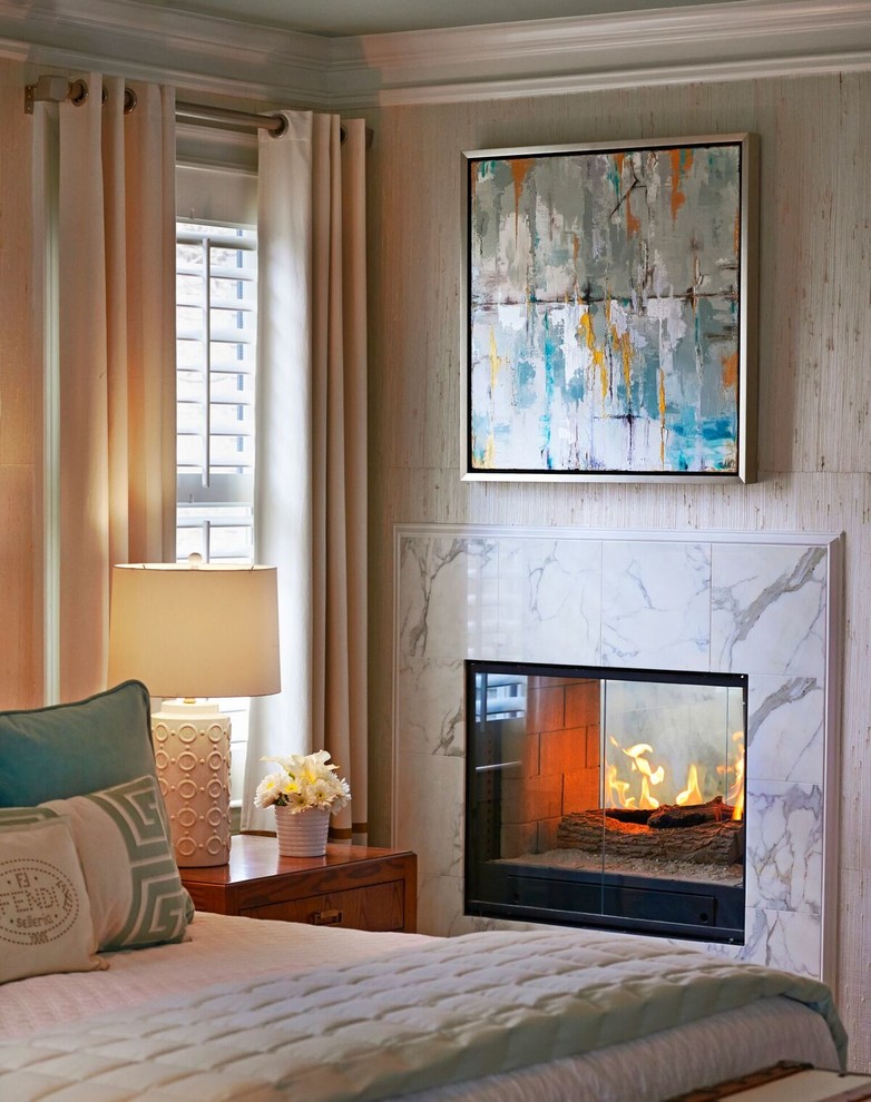 This is an example of a large classic guest bedroom in Atlanta with a two-sided fireplace and white walls.