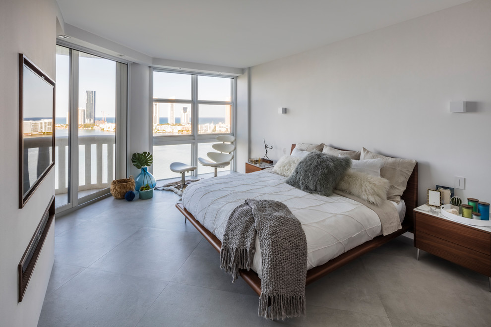 Стильный дизайн: хозяйская спальня в современном стиле с белыми стенами, бетонным полом и серым полом - последний тренд