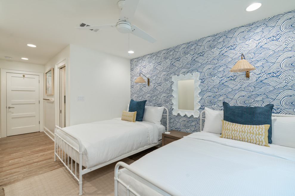На фото: спальня среднего размера в морском стиле с белыми стенами, паркетным полом среднего тона, двусторонним камином, фасадом камина из штукатурки и серым полом