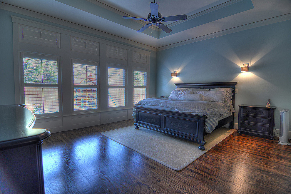 Foto de dormitorio principal tradicional sin chimenea con paredes azules y suelo de madera en tonos medios