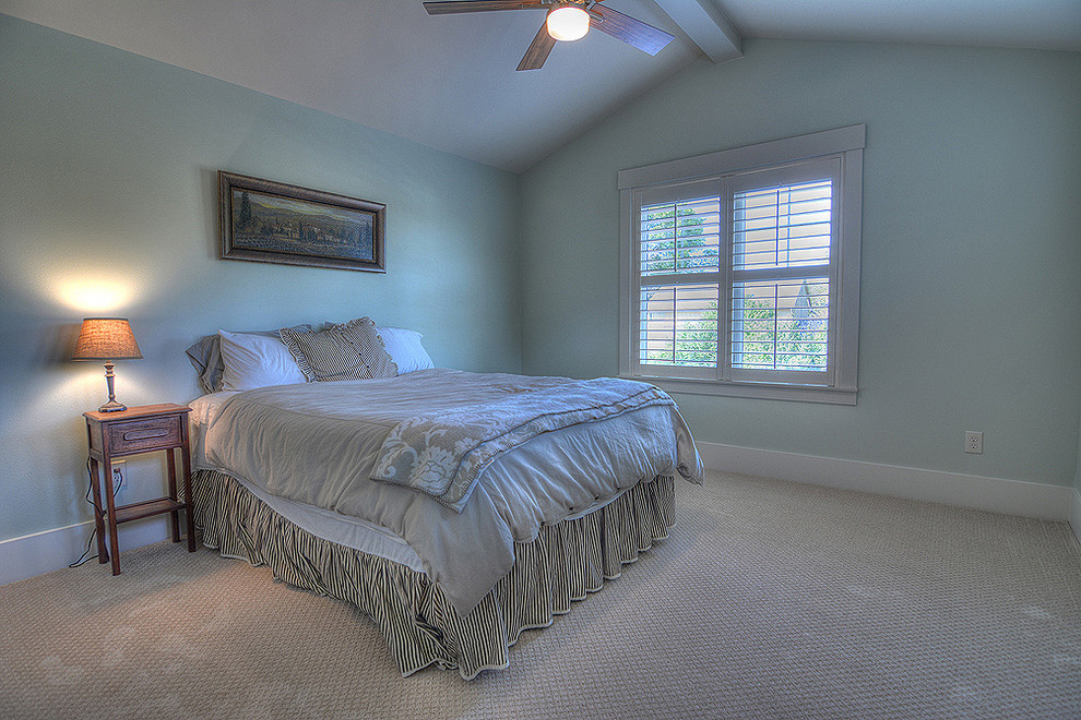 Modelo de habitación de invitados tradicional sin chimenea con paredes azules y suelo de madera en tonos medios
