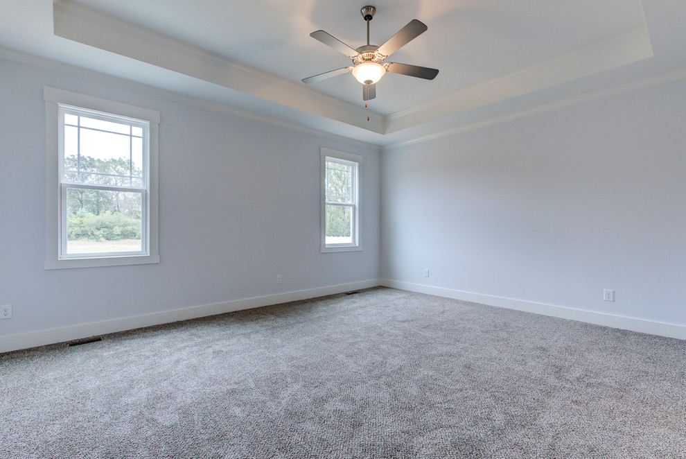 Example of a large arts and crafts master carpeted and gray floor bedroom design in Raleigh with gray walls