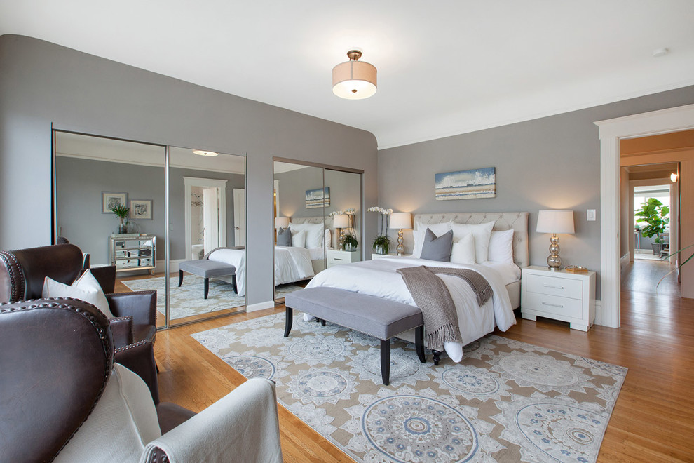 Foto de dormitorio clásico renovado sin chimenea con paredes grises y suelo de madera en tonos medios