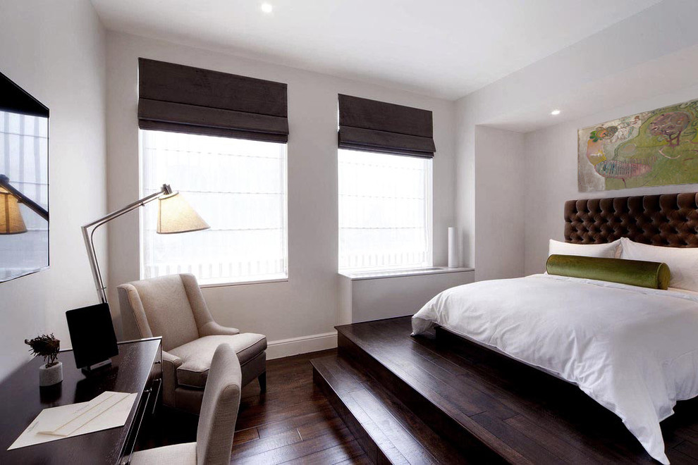 Large trendy loft-style dark wood floor and brown floor bedroom photo in New York with beige walls and no fireplace
