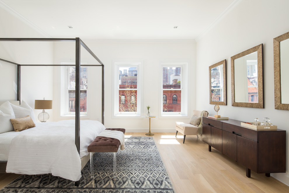 Trendy light wood floor and beige floor bedroom photo in New York with white walls and no fireplace