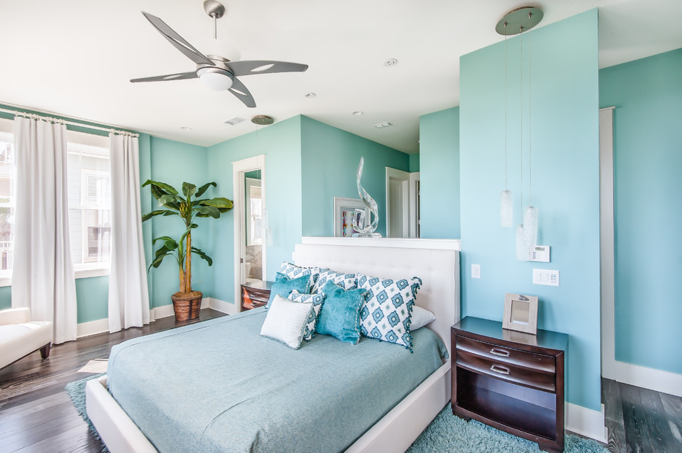 マイアミにあるトロピカルスタイルのおしゃれな寝室 (青い壁、濃色無垢フローリング)