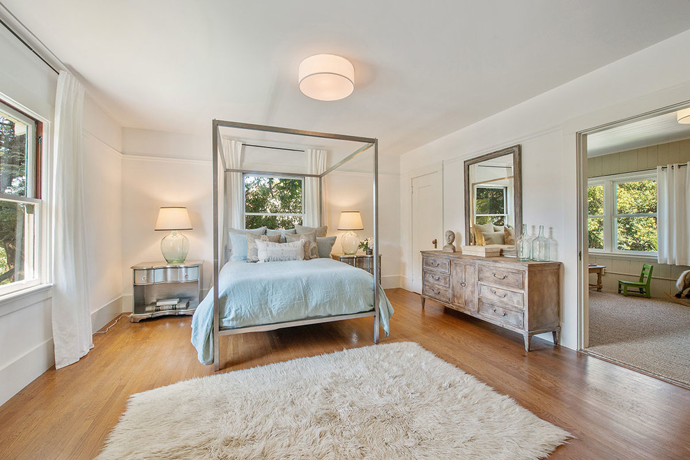 Diseño de dormitorio campestre con paredes blancas y suelo de madera en tonos medios