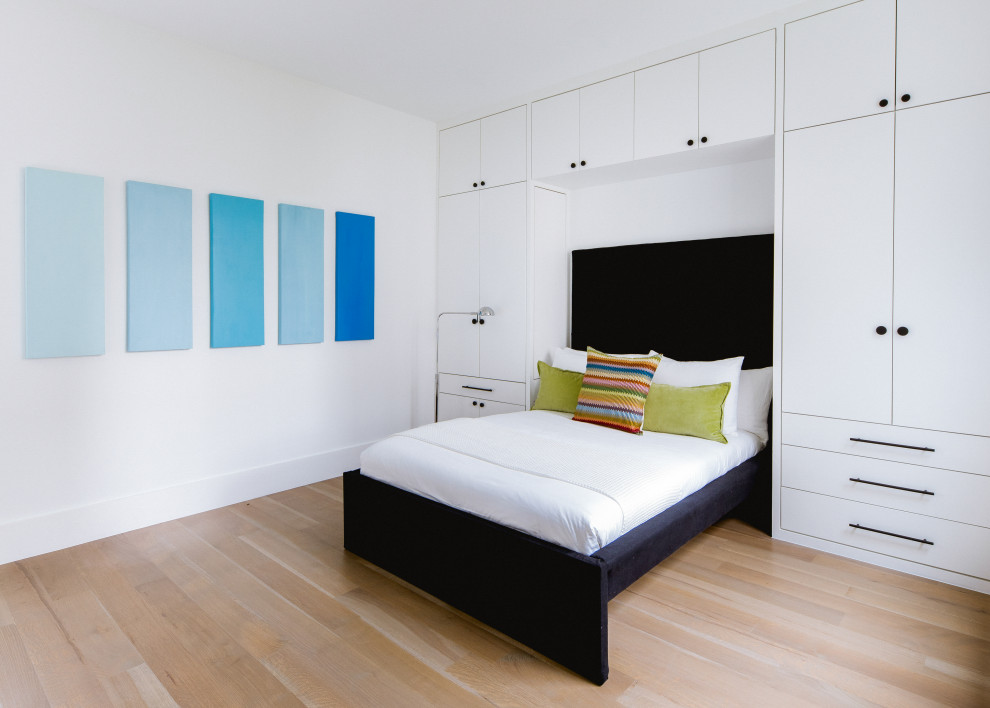 Modernes Schlafzimmer mit weißer Wandfarbe, braunem Holzboden und braunem Boden in Dallas