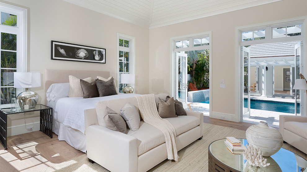 マイアミにある中くらいなトロピカルスタイルのおしゃれな主寝室 (ベージュの壁、淡色無垢フローリング、暖炉なし、ベージュの床)