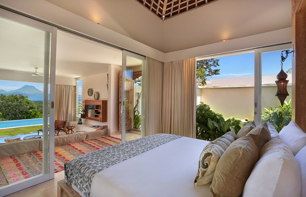 Ejemplo de dormitorio principal tropical de tamaño medio con paredes blancas