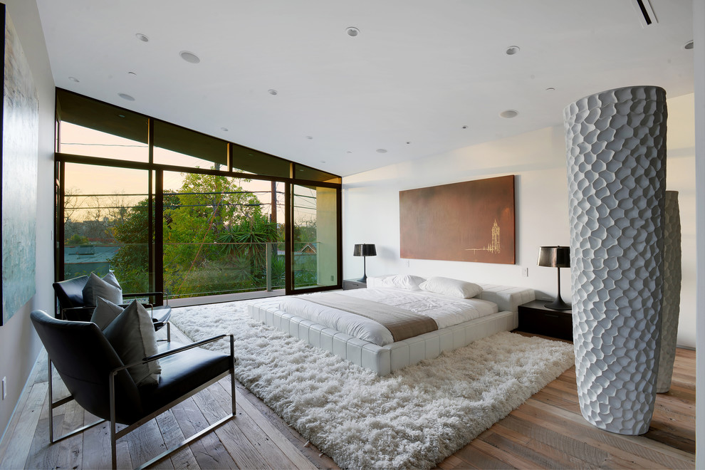 Aménagement d'une chambre contemporaine avec un mur blanc, un sol en bois brun et aucune cheminée.
