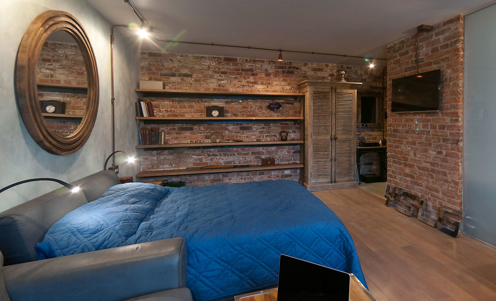 На фото: хозяйская спальня на мансарде в стиле лофт с коричневыми стенами и паркетным полом среднего тона с