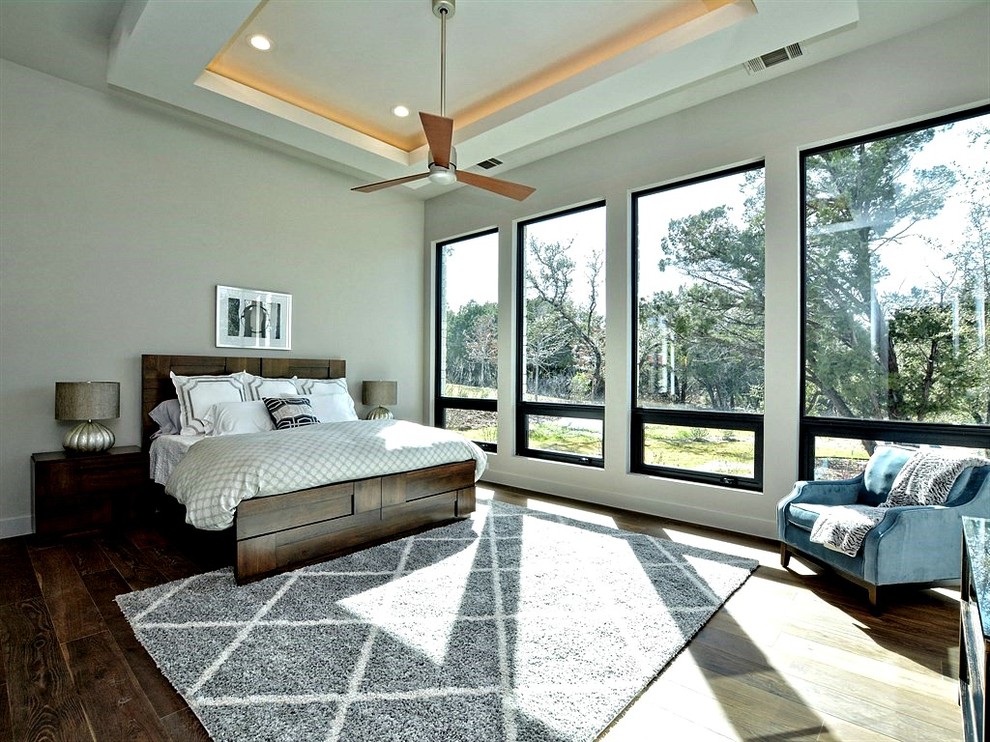 Großes Modernes Hauptschlafzimmer mit weißer Wandfarbe und braunem Holzboden in Austin
