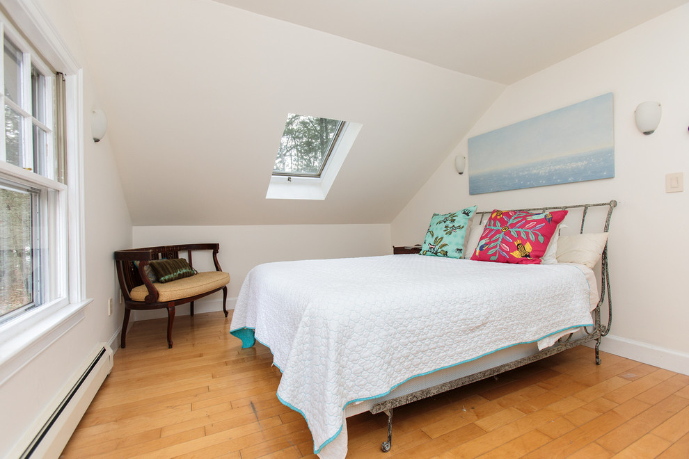 Imagen de habitación de invitados actual de tamaño medio con paredes blancas y suelo de madera en tonos medios