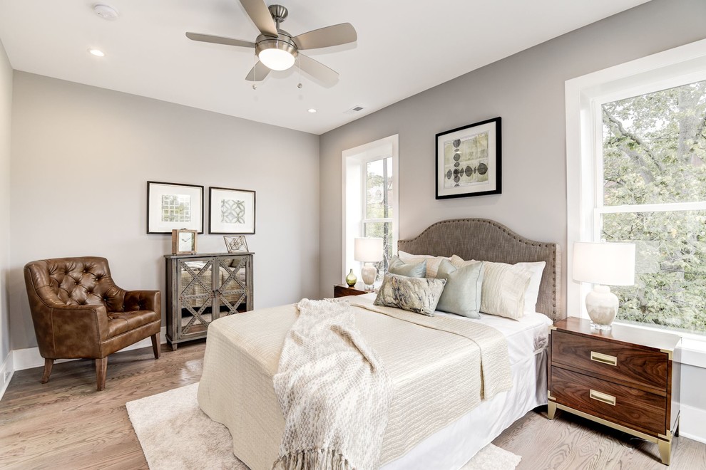 Diseño de habitación de invitados clásica renovada de tamaño medio sin chimenea con paredes grises, suelo de madera en tonos medios y suelo marrón