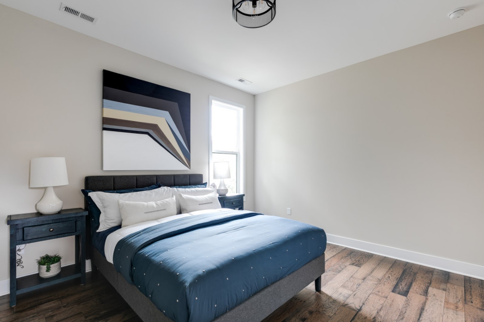 Ispirazione per una camera degli ospiti moderna di medie dimensioni con pareti beige, pavimento in legno massello medio e pavimento marrone