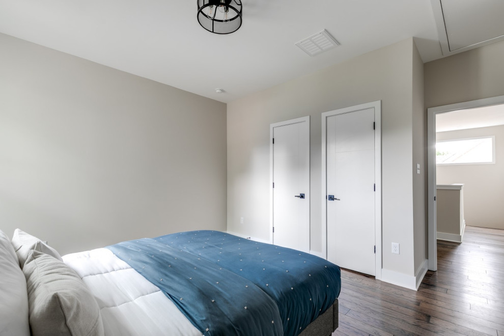 Mid-sized mid-century modern guest medium tone wood floor and brown floor bedroom photo in Richmond with beige walls