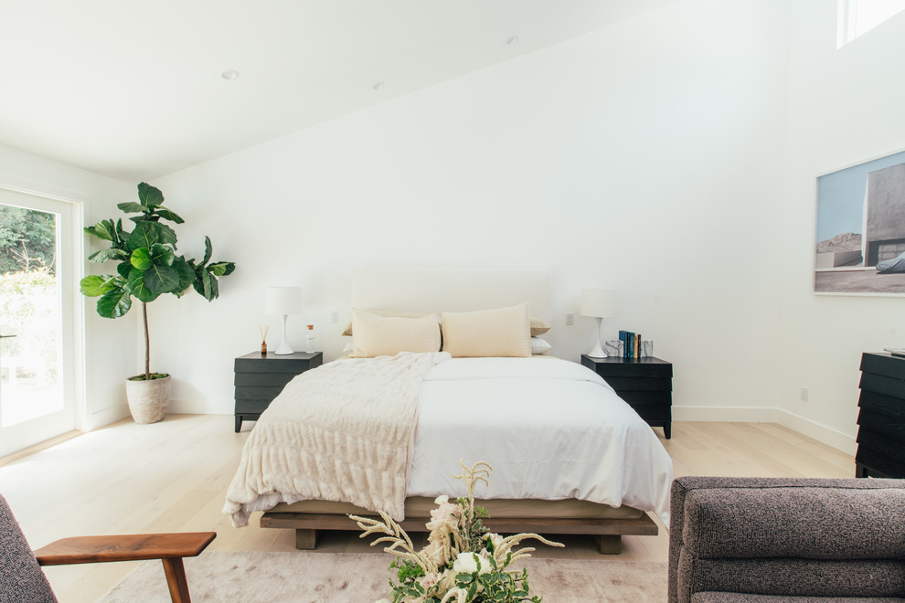 Imagen de dormitorio principal actual con paredes blancas, suelo de madera clara y suelo beige