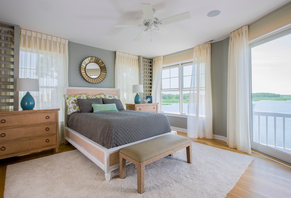 Immagine di una camera da letto stile marinaro con pareti grigie e pavimento in legno massello medio