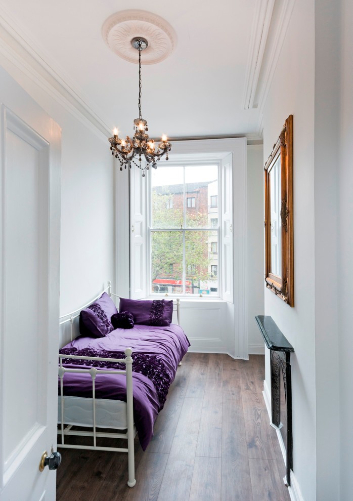 ダブリンにある小さなトランジショナルスタイルのおしゃれな客用寝室 (白い壁、濃色無垢フローリング、金属の暖炉まわり、茶色い床) のインテリア