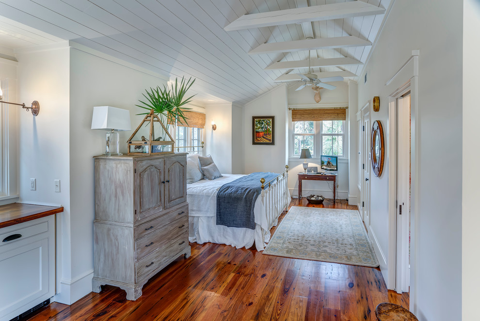 Imagen de dormitorio marinero con paredes blancas y suelo de madera en tonos medios