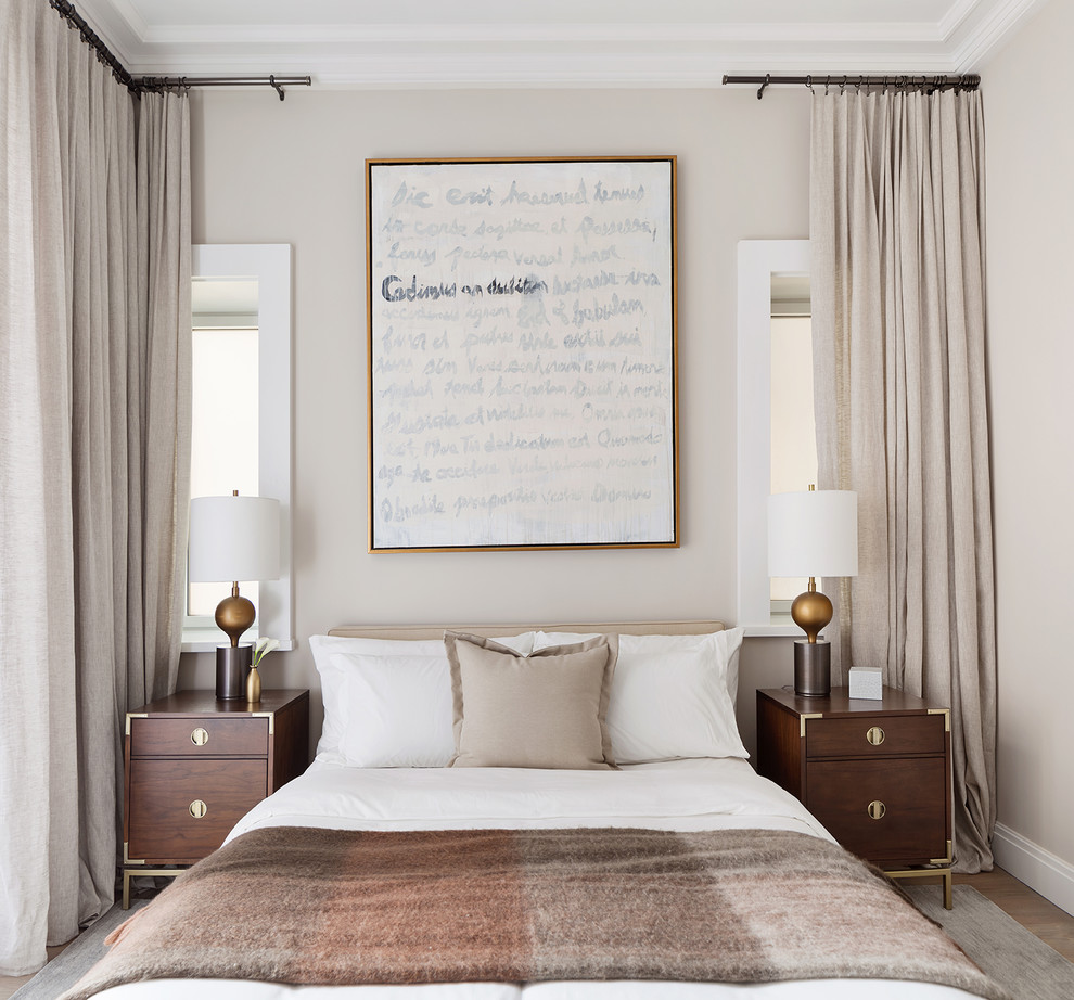 Diseño de dormitorio actual con paredes beige, suelo de madera en tonos medios y suelo marrón