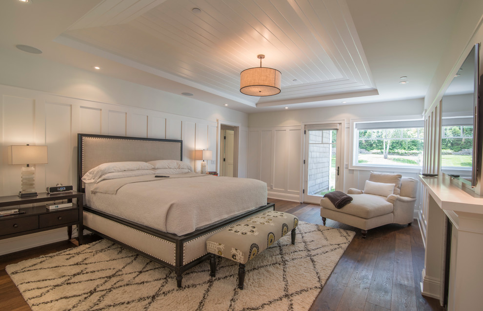 Großes Klassisches Hauptschlafzimmer mit weißer Wandfarbe, braunem Holzboden, Kamin und Kaminumrandung aus Holz in Los Angeles