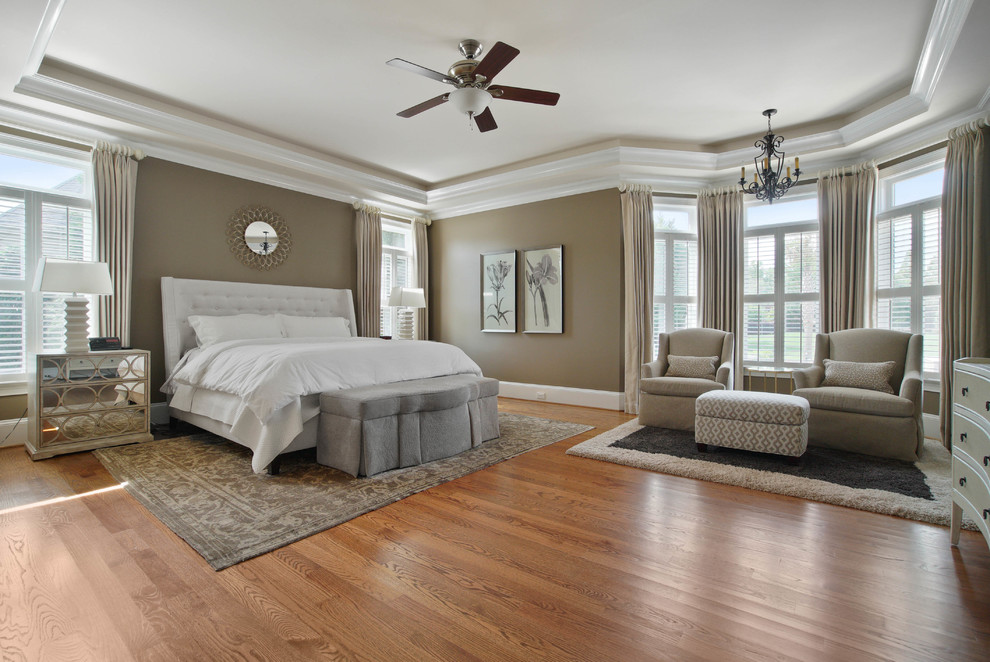 Immagine di una camera da letto tradizionale con pareti marroni, pavimento in legno massello medio e pavimento marrone