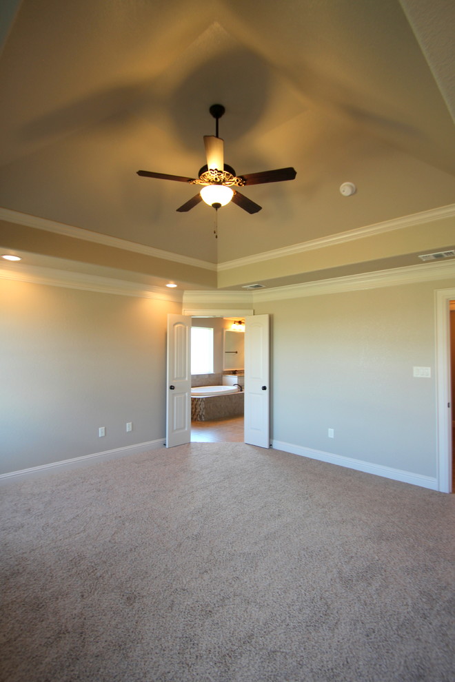 Example of a large master carpeted bedroom design in Dallas with beige walls