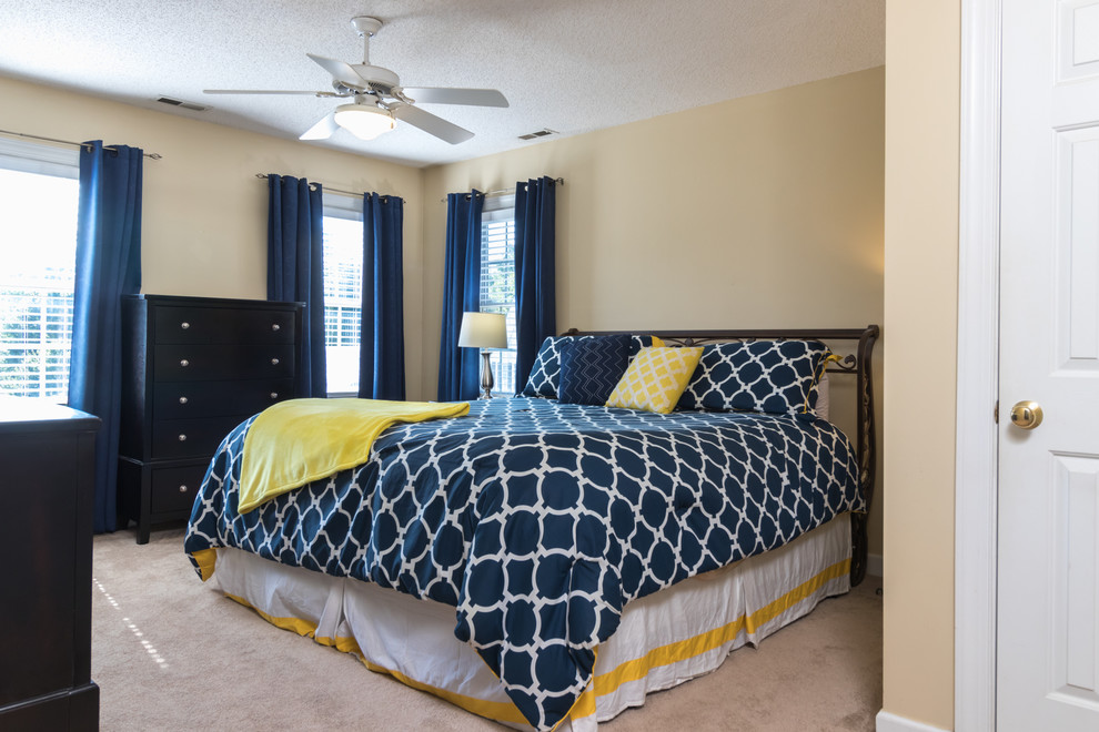 Kleines Klassisches Hauptschlafzimmer mit gelber Wandfarbe, Teppichboden und braunem Boden in Raleigh