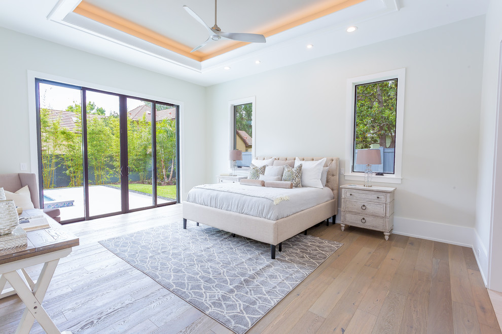Modelo de habitación de invitados tradicional renovada de tamaño medio con paredes beige, suelo de madera clara, suelo beige y casetón