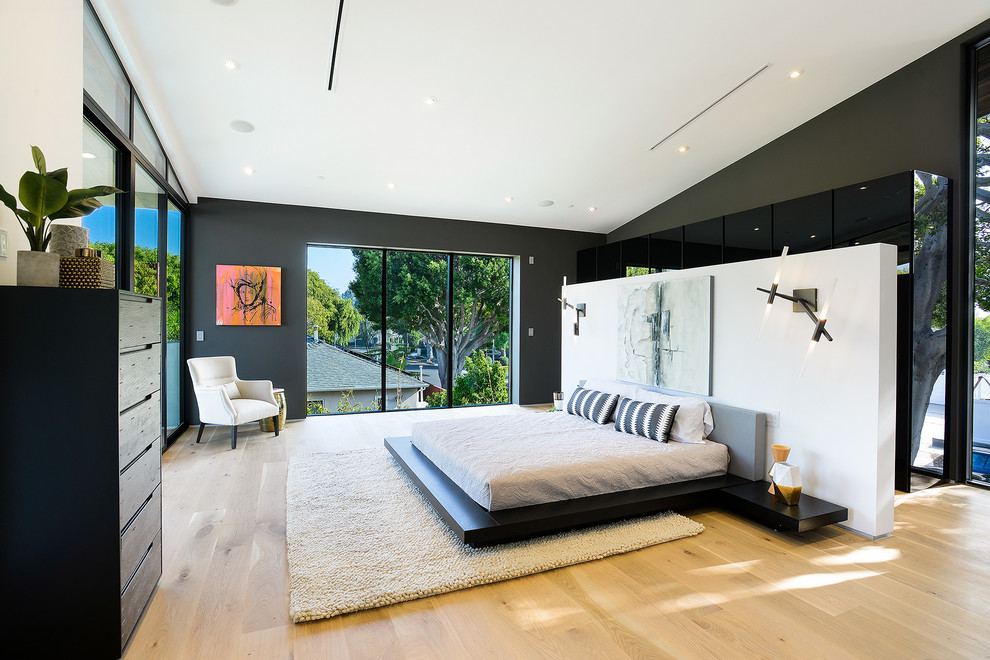 Inspiration for a large modern master light wood floor and brown floor bedroom remodel in Los Angeles with black walls and no fireplace