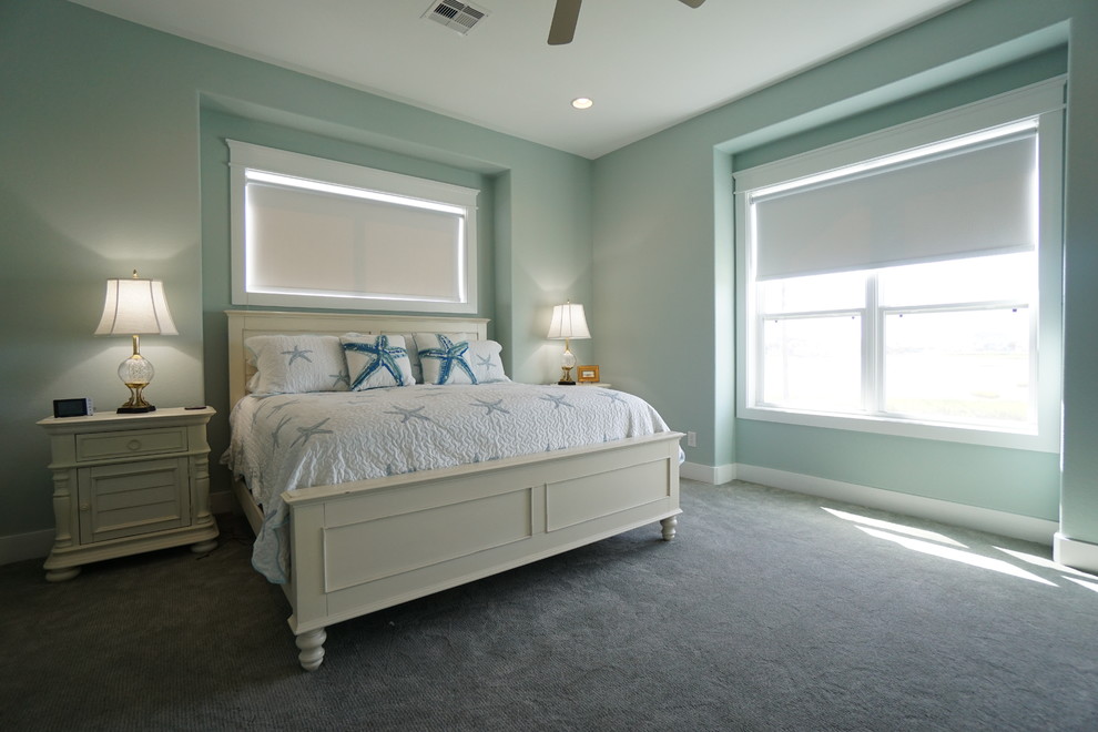 Imagen de dormitorio principal costero grande sin chimenea con paredes azules y moqueta