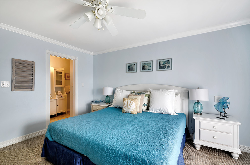 Immagine di una camera da letto costiera con pareti blu e moquette