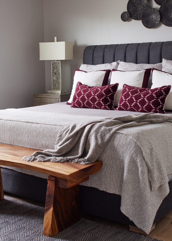 Ejemplo de dormitorio principal clásico de tamaño medio sin chimenea con paredes grises, suelo de madera clara y suelo beige